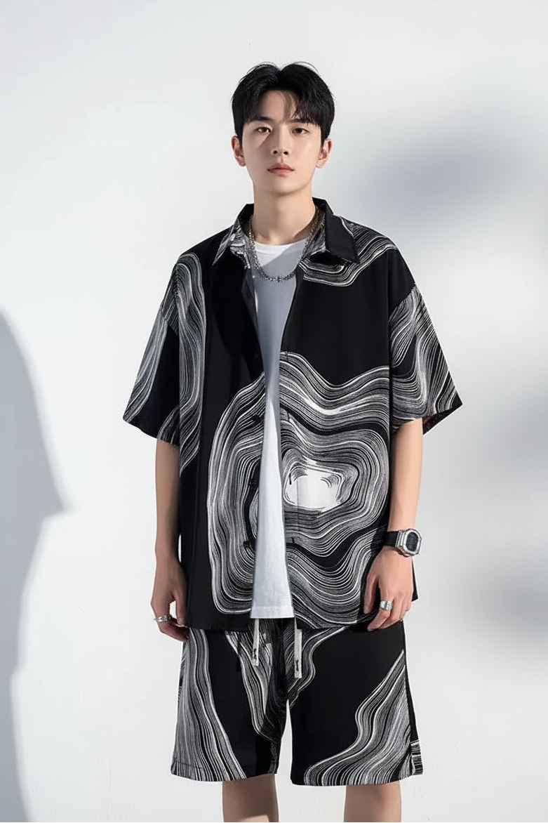 Person wearing a black and gray patterned outfit with a white background